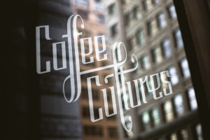 Coffee Cultures window decal with buildings reflected