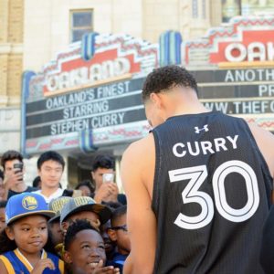 Stephen Curry wearing his #30 jersey in front of The Fox Theater with onlookers