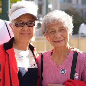 2 senior women wearing vote stickers