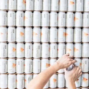 Elemental Beverage Co. wall of cans with hands