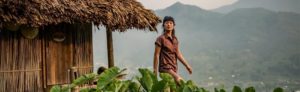 Woman outside a thatched roof structure