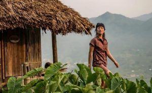 Woman outside a thatched roof structure