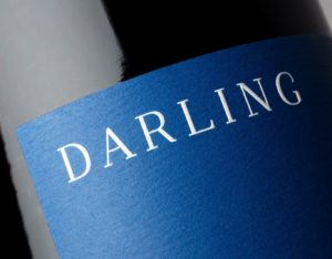Close up of Darling Wines logotype on bottle label, white against deep blue