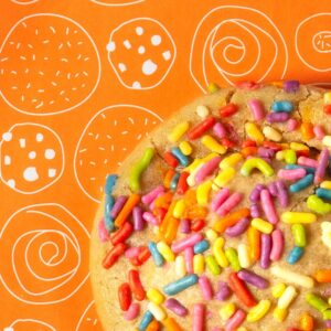 PB&J cookie with colorful sprinkles on branded orange tissue paper