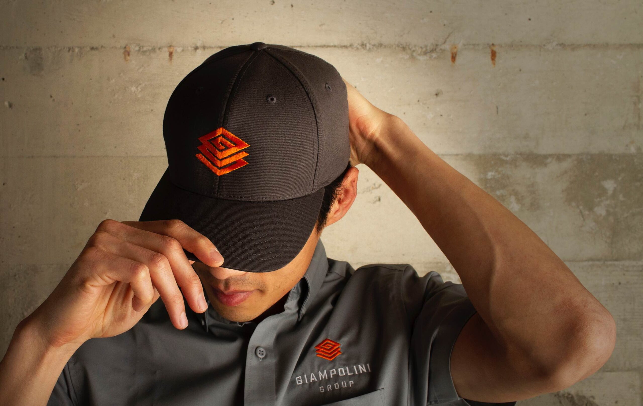 Man wearing branded Giampolini Group cap and work shirt