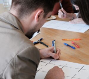 A team member working on a strategy exercise with pen and paper