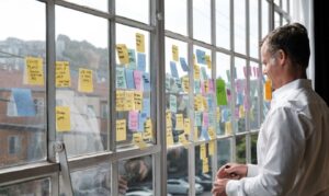 Stakeholder reviewing post-it notes in front of a window during a strategy workshop