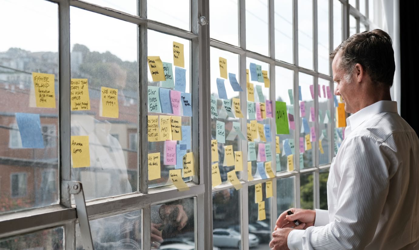 A team member reviewing post-it notes in front of a window