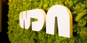 close-up of lobby front desk logo signage surrounded by foliage